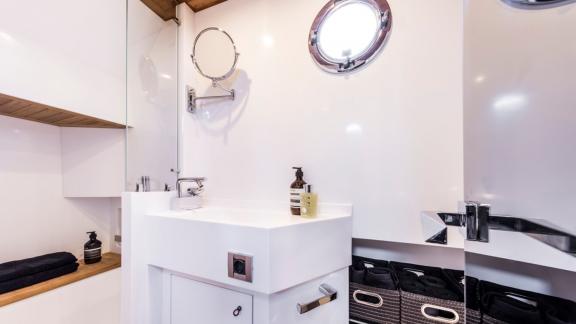Among Monaco yacht charter options Cest Party motor yacht shows bathroom with sink and organized storage space.