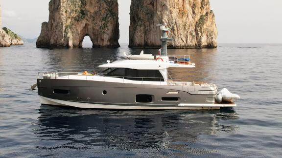 Die Motoryacht Ciu Ciu ankert vor den berühmten Faraglioni-Felsen auf Capri – perfekt für eine Tagescharter in Neapel.