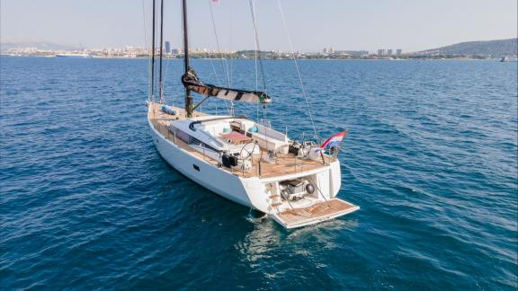 Among sailing yacht rental options in Kastela Bubbles is seen cruising with aft deck and swim platform in open sea.