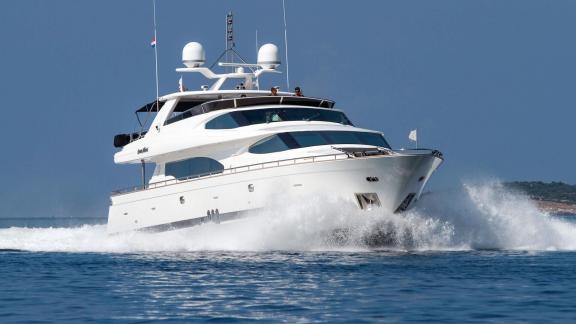 Horizon Elegance 90 Conte Alberti is seen underway with waves breaking around its bow on open waters.