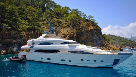 Crn 128 Ariela anchored among lush cliffs and clear waters, ready for charter in Göcek.