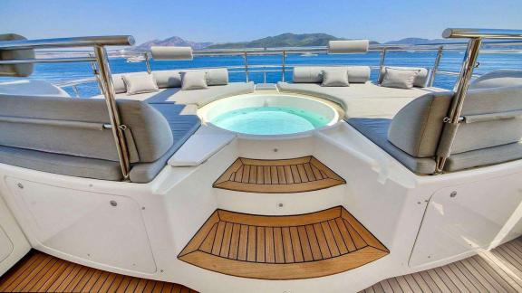 Ariela yacht anchored in Göcek features a round jacuzzi surrounded by cushioned seating and sea views.