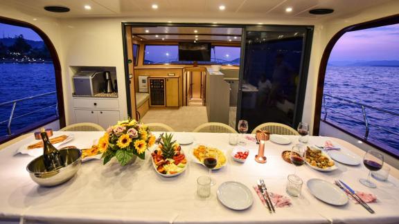 Among motor yacht rental options in Gocek Dalibay 2 aft deck shows dining table and entrance to interior salon.