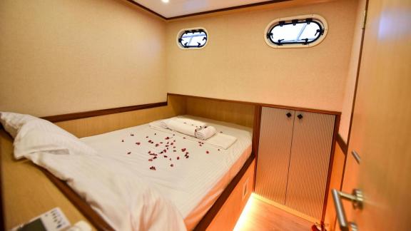 Among motor yacht rental options in Gocek Dalibay 2 cabin shows double bed with ambient lighting and seating areas.