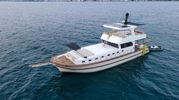 Among motor yacht rental options in Gocek Dalibay 2 is seen anchored with deck and upper structure in calm sea.