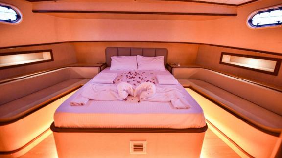 Among motor yacht rental options in Gocek Dalibay 2 cabin shows double bed with ambient lighting and seating areas.