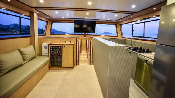 Among motor yacht rental options in Gocek Dalibay 2 interior shows lounge seating and open kitchen layout onboard.