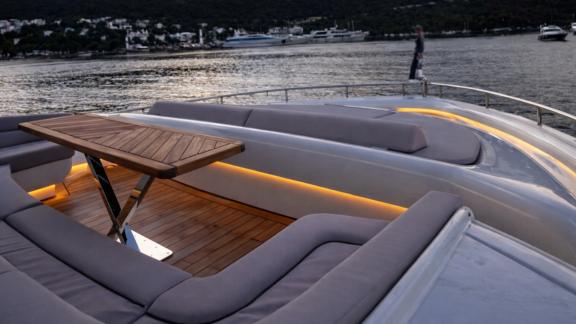 The foredeck of Den Den motor yacht in Bodrum features a wide seating and table area for daily yacht rental trips.