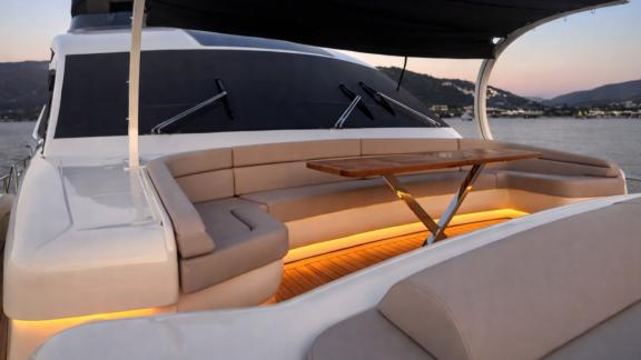The foredeck of Den Den motor yacht in Bodrum features a cozy seating and table area for daily yacht rental.