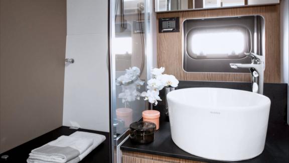 Discovery Bay motor yacht features a stylish bathroom with a modern sink design and shower area onboard.