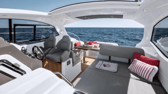 Discovery Bay motor yacht features captain seats and a comfortable lounge area with open sea views on the main deck.
