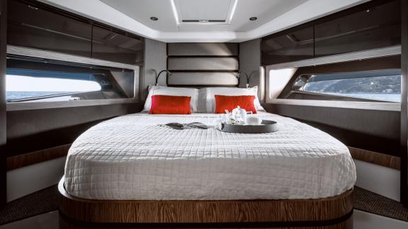 Discovery Bay motor yacht features a modern double cabin with a spacious bed and panoramic sea view windows.