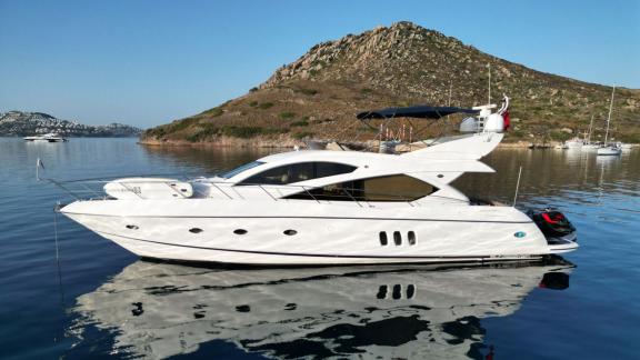 The Distraction motor yacht is anchored in the calm waters of Bodrum, waiting in a peaceful setting.