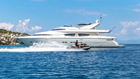 A jet ski speeds alongside the luxury yacht Divine, adding fun on the water.