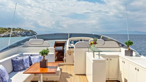 Seating area with sofa, table, and minibar on Divine's flybridge.