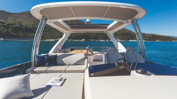 The spacious flybridge seating area of Emilia 2 offers a scenic view of the sea.