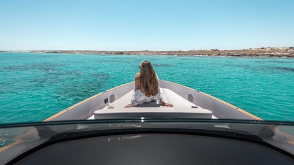 Eine Frau entspannt sich auf dem Vorderdeck der Motoryacht Endless Summer im klaren Wasser.