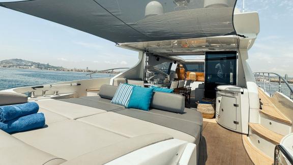 The aft deck of motor yacht Esperanza features a spacious shaded lounge area with comfortable cushions, offering a relax