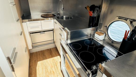 The kitchen on motor yacht Esperanza is compact and functional, equipped with modern appliances and a window with a sea