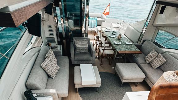 The aft lounge of motor yacht Esperanza offers a stylish atmosphere with comfortable seating and a large dining table.