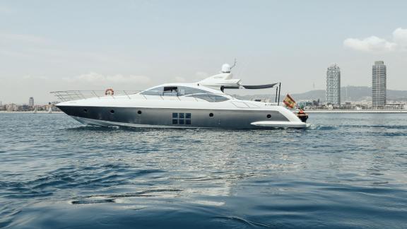 The motor yacht Esperanza cruising with a city skyline in the background.