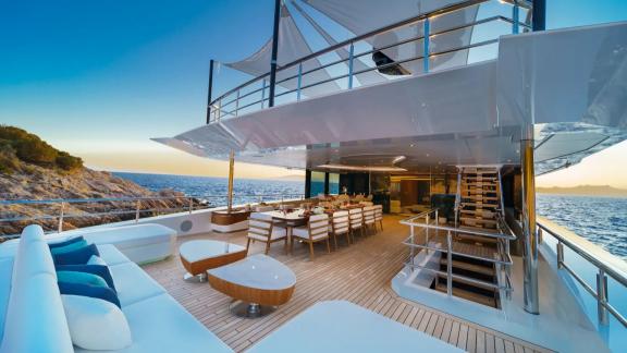 The aft deck on Eternal Spark features elegant dining and lounge areas for luxury yacht charter experiences.