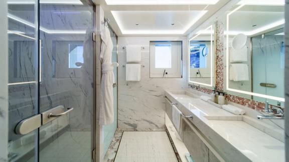 The bathroom on Eternal Spark features spacious showers and elegant marble interiors for luxury yacht charter stays.
