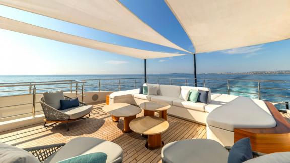 The upper deck lounge of Eternal Spark offers sea views and elegant seating during luxury yacht charter trips.