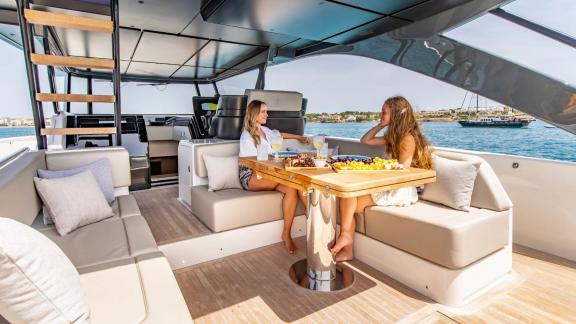 Auf dem Heck der Motoryacht Experience genießen Gäste eine Mahlzeit mit Meerblick.