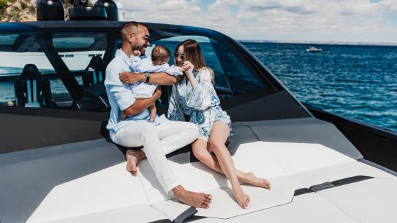 A family enjoys beautiful moments on the front deck of the Figo motor yacht at sea.