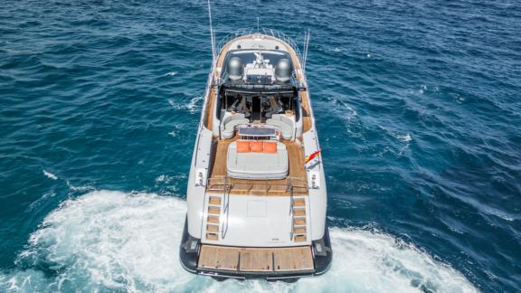 The motor yacht Five Stars stands out with its wide aft deck, viewed from the rear at sea.