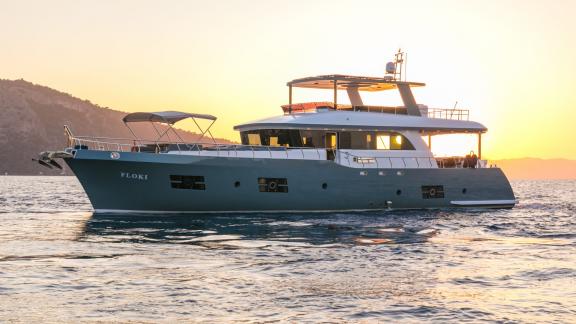 The Floki trawler yacht at sea during sunset, seen from the side profile.