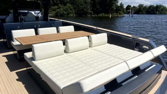 Among Saint Tropez yacht charter options Fortitude motor yacht shows aft lounge with table and large sunbed.