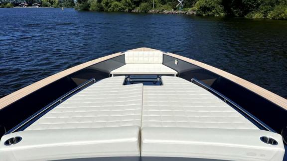Among Saint Tropez yacht charter options Fortitude motor yacht shows front deck with large cushioned sunbathing area.