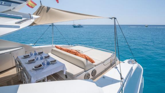 The aft deck of motor yacht Funky Town features an elegant dining table and a comfortable sunbathing area.