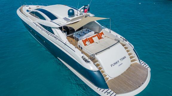 The aft deck of motor yacht Funky Town features comfortable sun loungers and a spacious seating area.