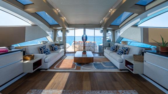 The salon of motor yacht Funky Town features large windows and doors leading to the aft deck.