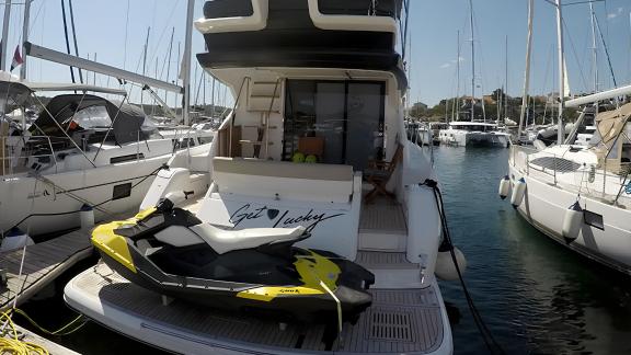 The aft deck of the Get Lucky motor yacht with a jetski, anchored in the marina. Ideal for fun activities.