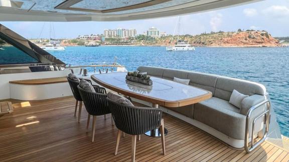 Monte Carlo 86 Giorgio features a modern dining table on the aft deck with sea views.