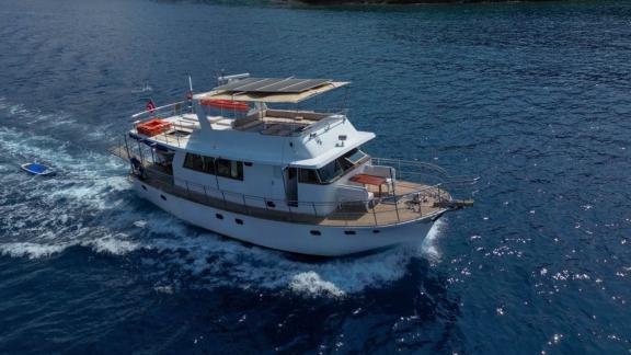 Exterior view of the trawler Grainne Mhaol cruising in the blue waters of Göcek.