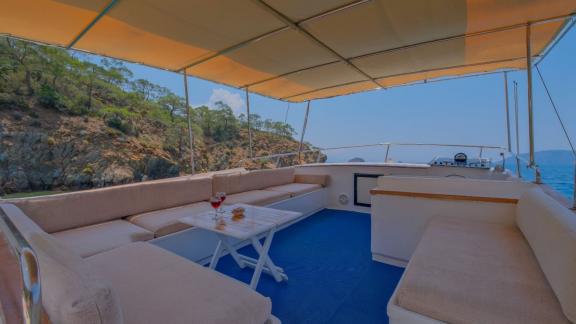 Spacious seating area on the flybridge of the trawler Grainne Mhaol with nature views.