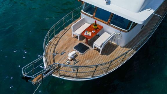 Cozy seating area with sea view and stylish table on the foredeck of the trawler Grainne Mhaol.