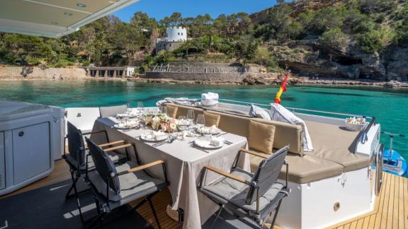 Among Mallorca yacht charter options Gran Abe II shows aft deck with dining table and seating.