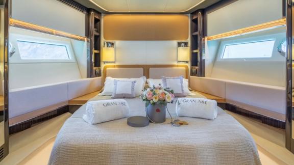 Among Mallorca yacht charter options Gran Abe II shows spacious cabin with bed and lighting.