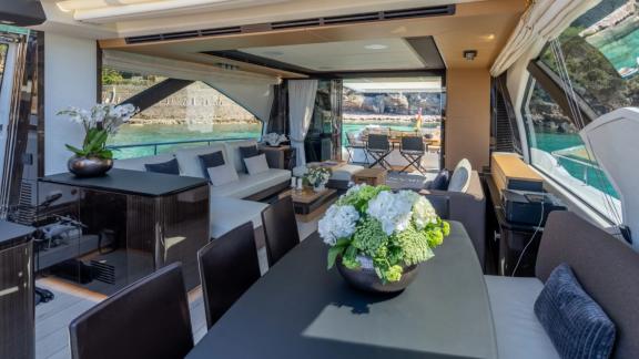 Among Mallorca yacht charter options Gran Abe II shows interior with dining table and seating.