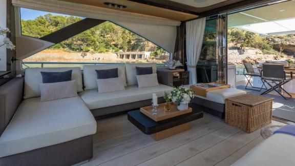 Among Mallorca yacht charter options Gran Abe II shows lounge with sofa and ocean view.