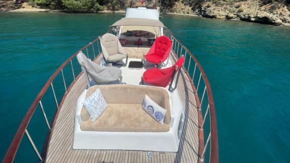 Motor yacht Grida anchored in a bay, foredeck seating areas are very comfortable.