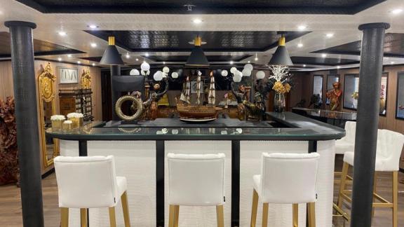 Die elegante Bar der Motoryacht Harmony II bietet weiße Stühle und dekorative Accessoires.