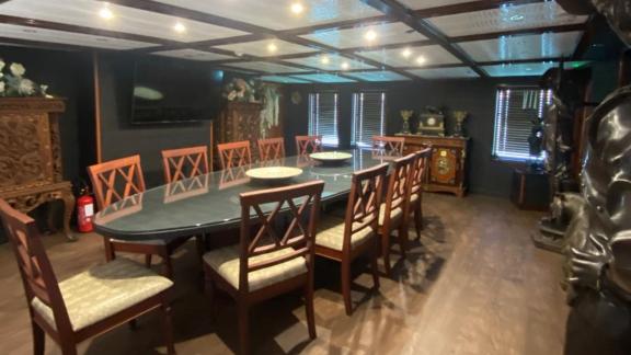 The dining room on Harmony II yacht features a long table and elegant chair arrangement.