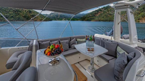 The flybridge of the motor yacht Ibiza in Bodrum offers comfortable seating and fruit platters.